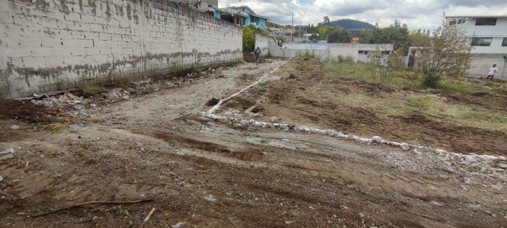 Terreno con marcas de delimitación y barro, mostrando el inicio de lotización para Conocoto residencial inversión.