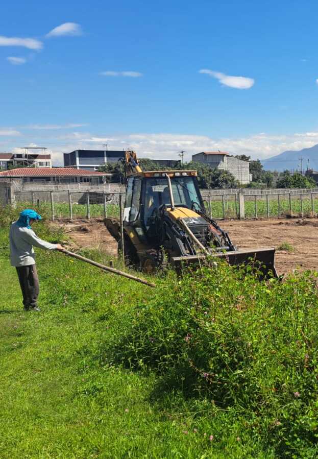 Trabajador realizando limpieza de terreno y despeje en obra de BCI en Quito.