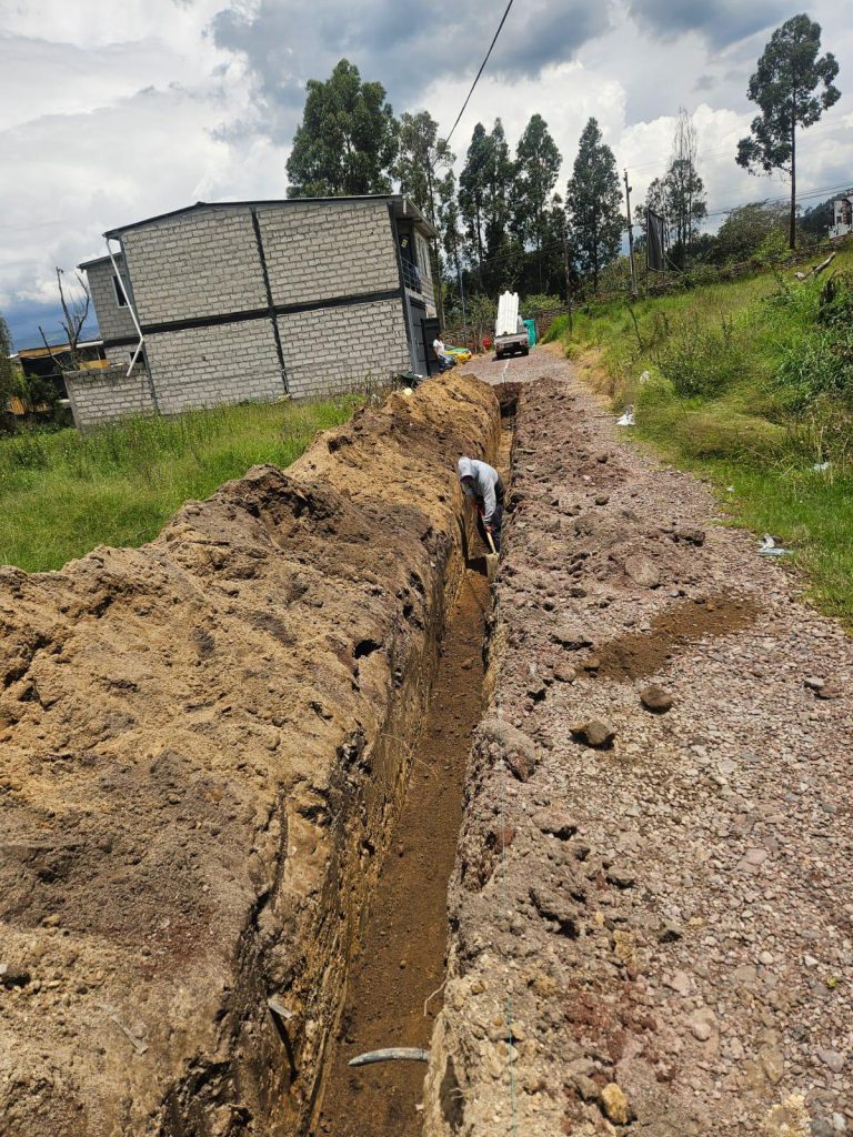 Obrero supervisando la instalación de tubería, desarrollo de infraestructura en terrenos inversión Pinos La Salle.