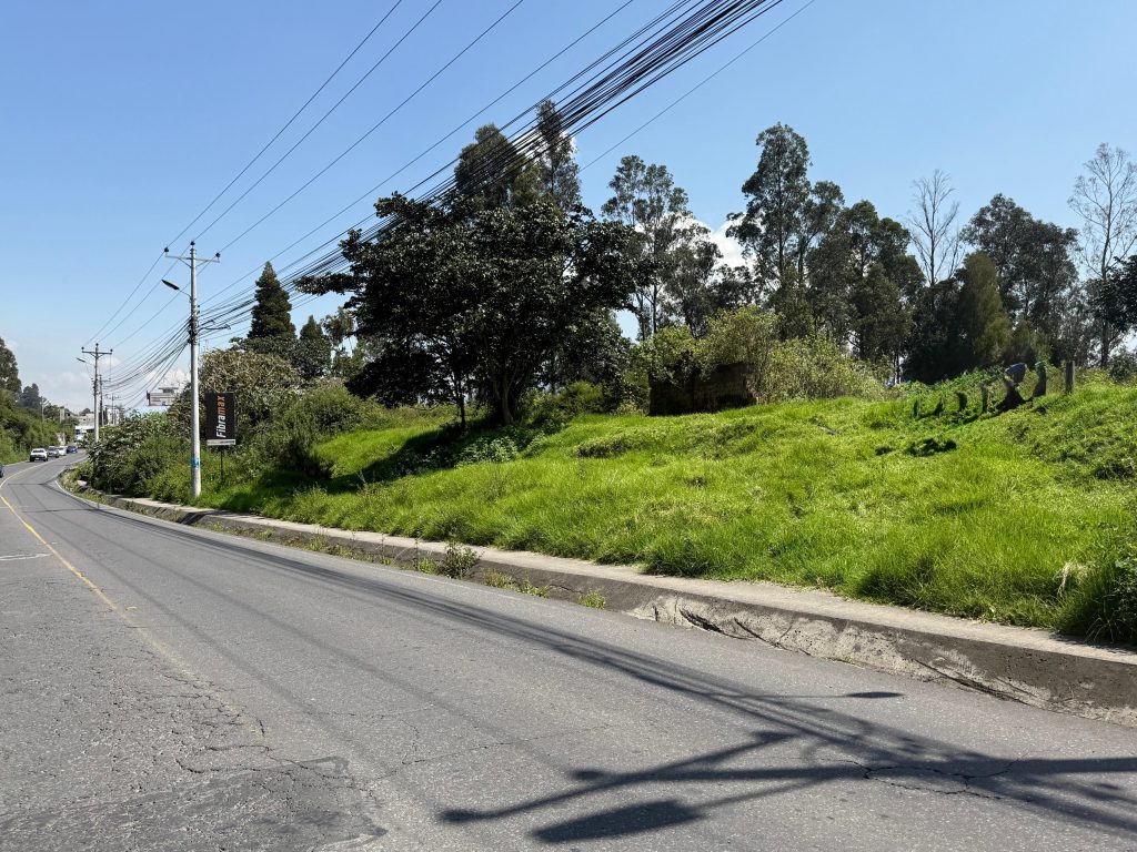 Vista amplia del terreno desde la vía, confirmando la ubicación privilegiada para inversión en Conocoto La Salle.