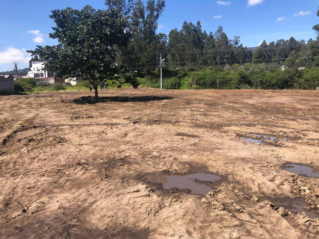 Terreno limpio y desbrozado con charcos, evidenciando la preparación para inversión en Conocoto La Salle.