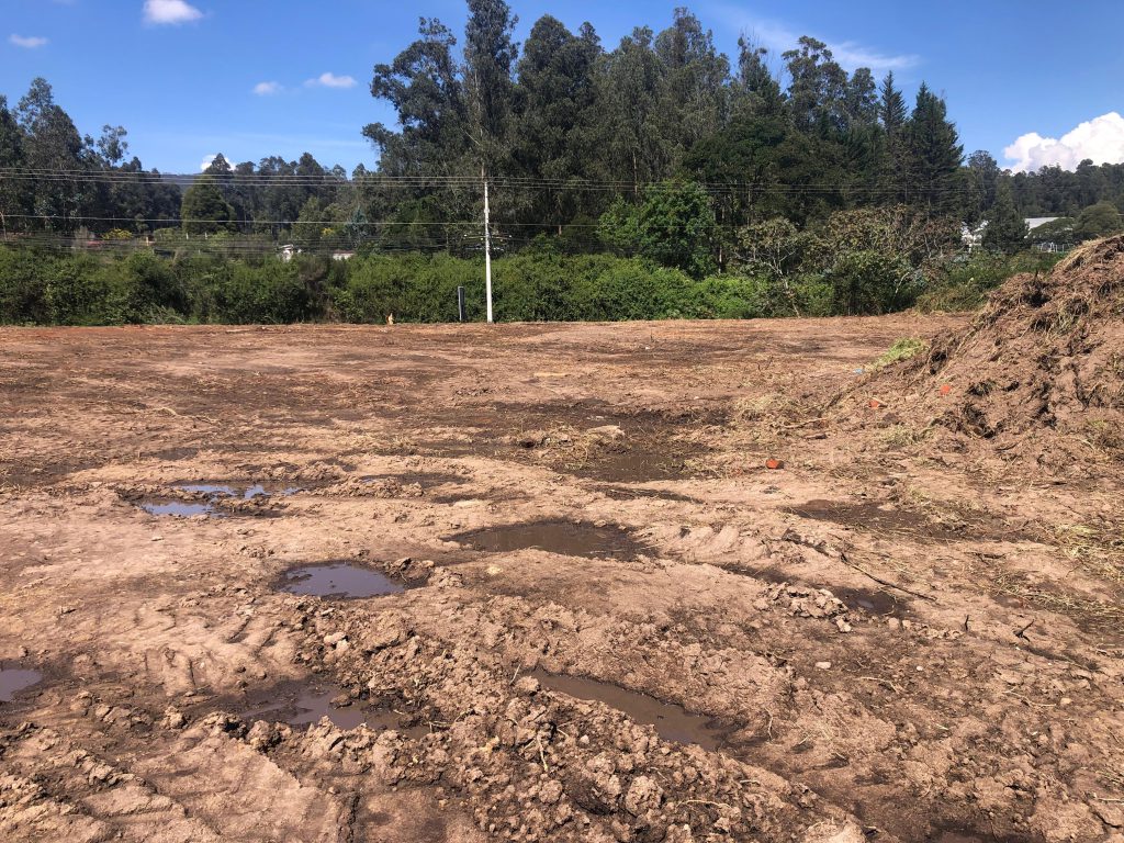 Terreno limpio con charcos y huellas de maquinaria, evidenciando la preparación para inversión en Conocoto La Salle.