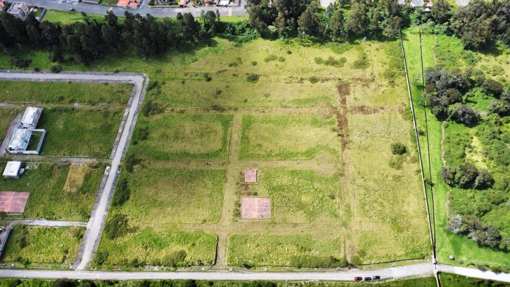 Vista aérea del terreno lotizado con divisiones marcadas, listo para inversión en terrenos Conocoto crecimiento.